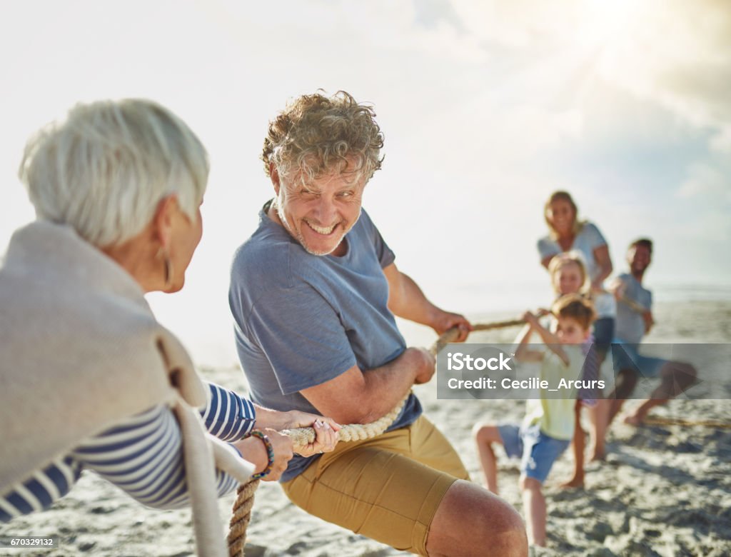 three generations pulling rope at the beach